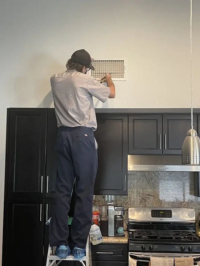 Technician inspecting an air vent during HVAC service in Bainbridge